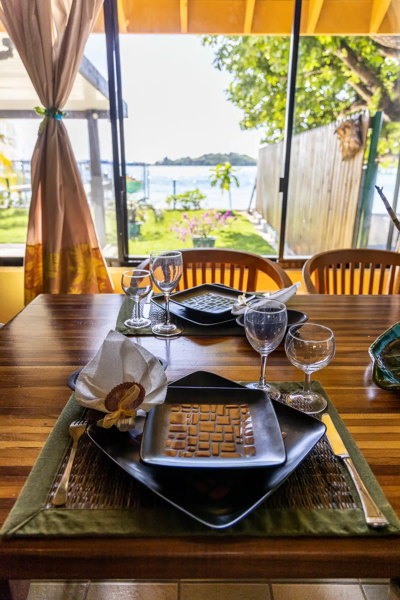Dining table at Fare Manava with a wide lagoon window view