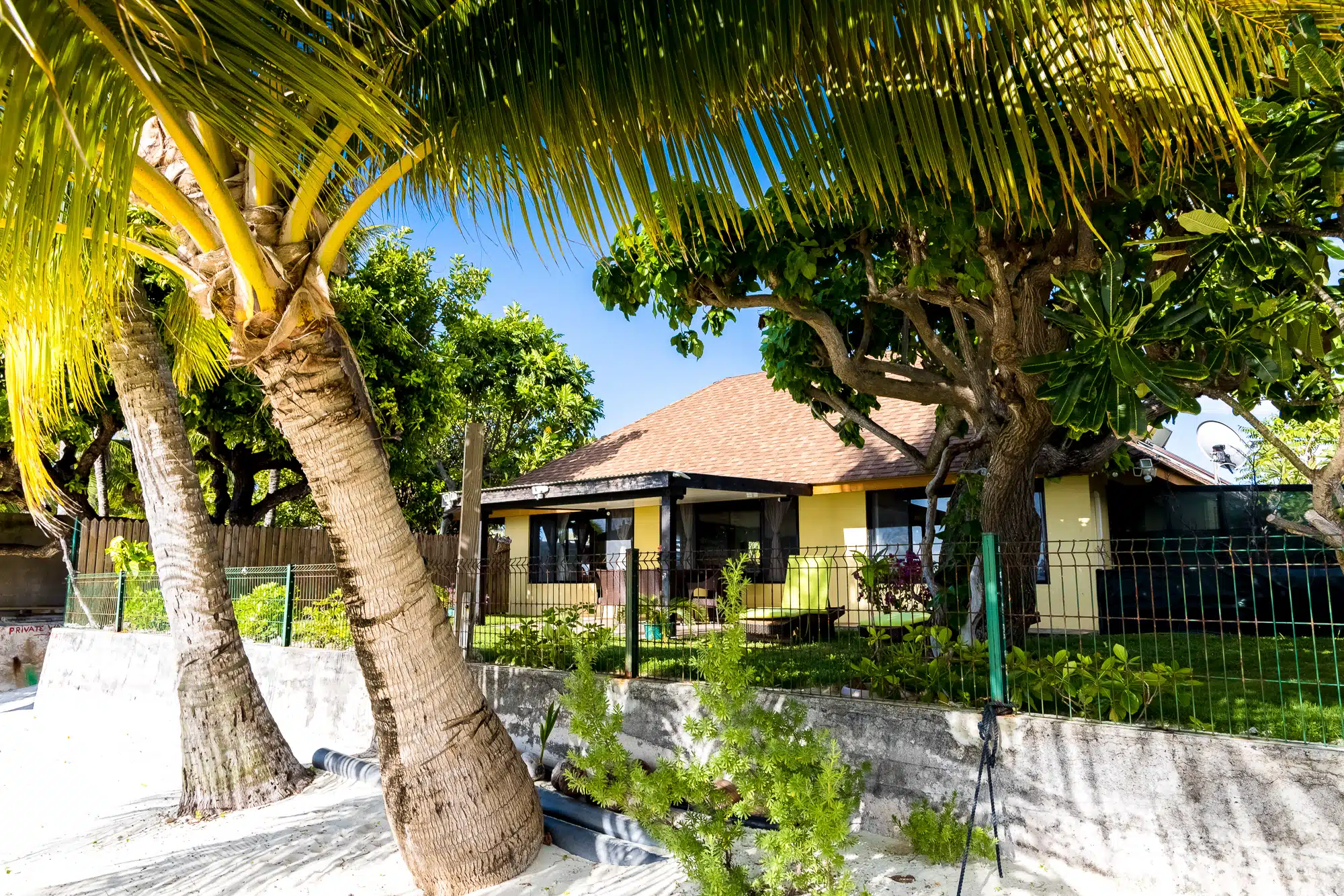 Fare Manava beachfront exterior with palm trees on Matira Beach, Bora Bora